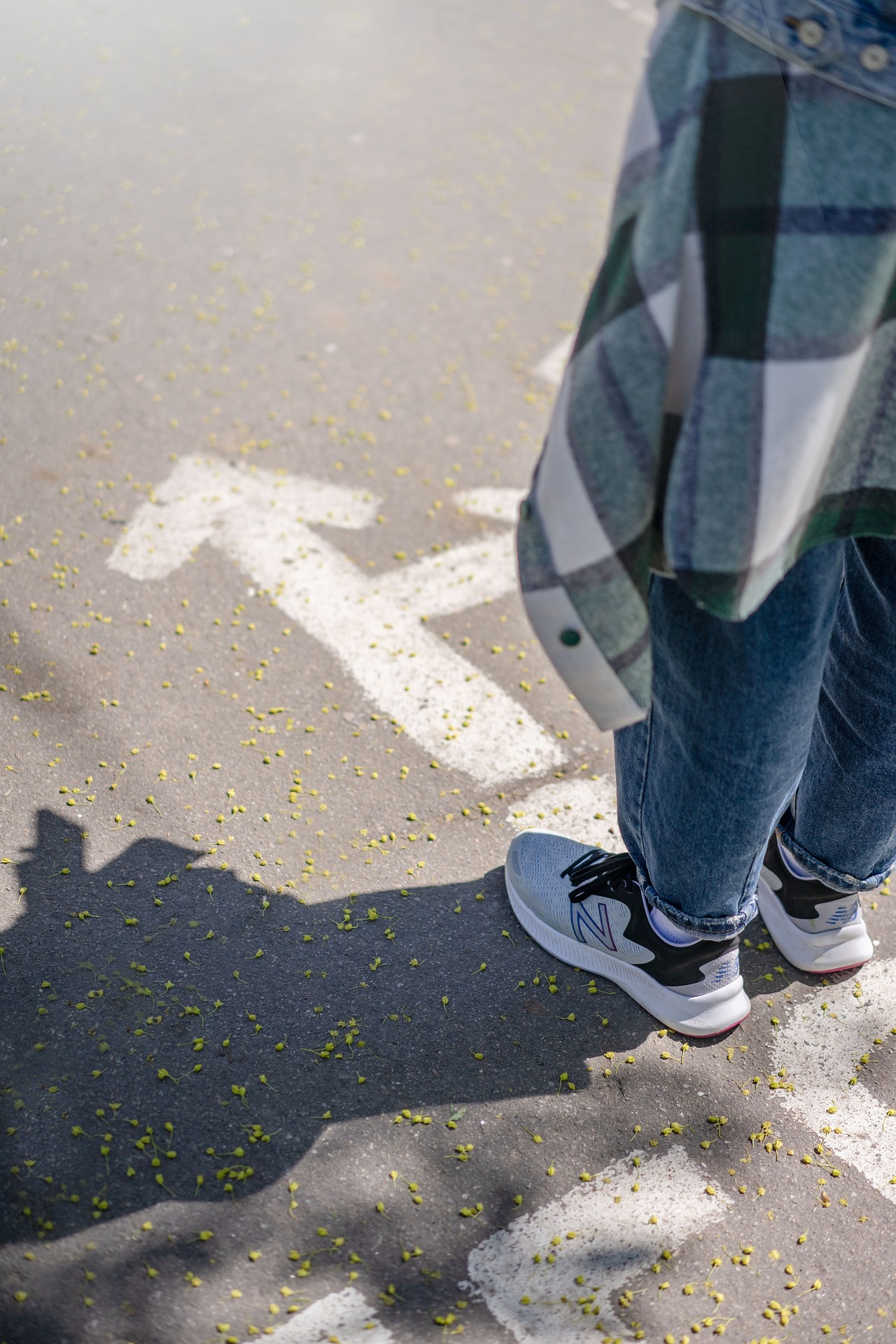 Person steht vor einem Pfeil auf dem Boden